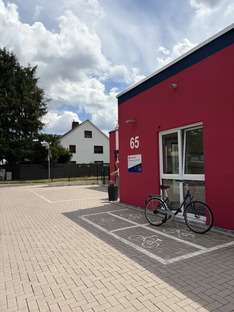 Roter Eingangskubus des Objektbaus mit Hausnummer